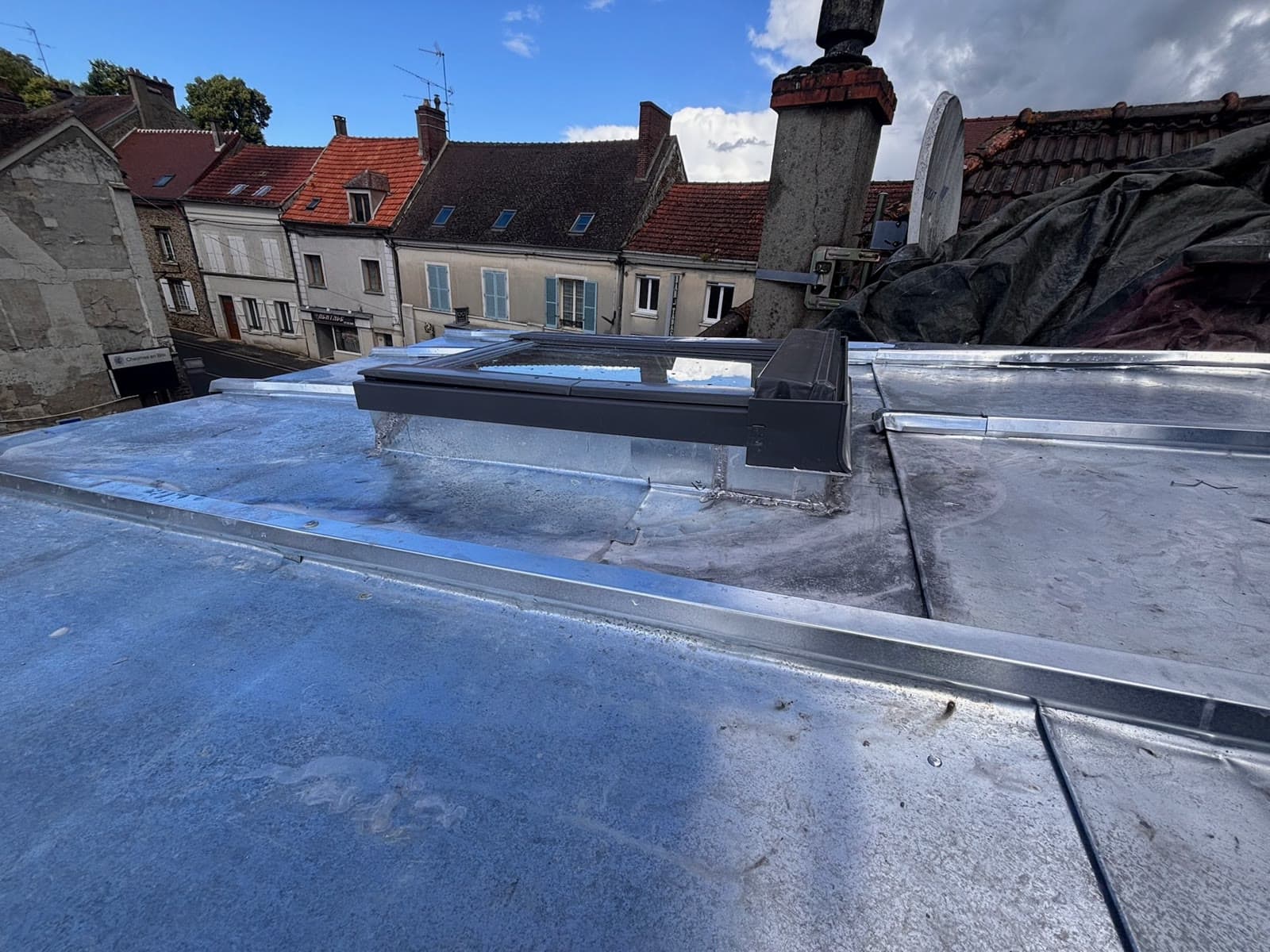 Pose des feuilles de zinc autour de la fenêtre de toit