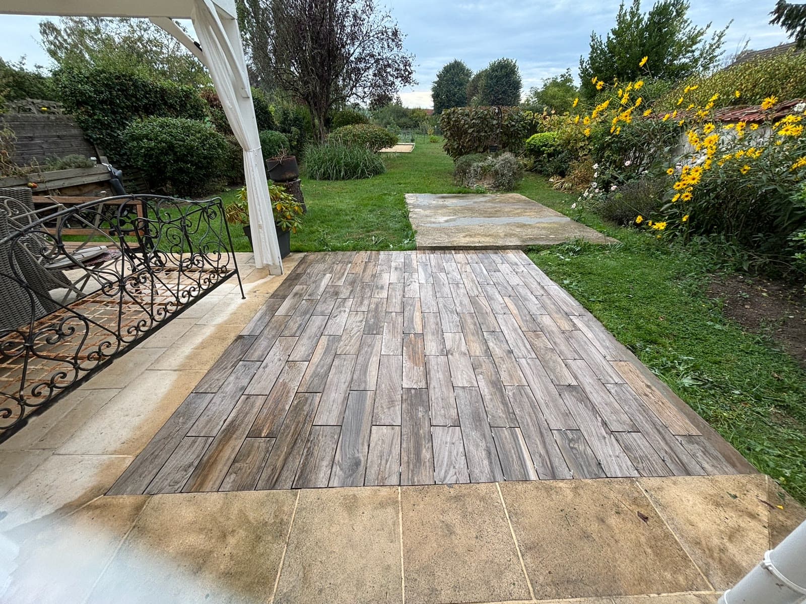 Terrasse extérieure rénovée devant un jardin